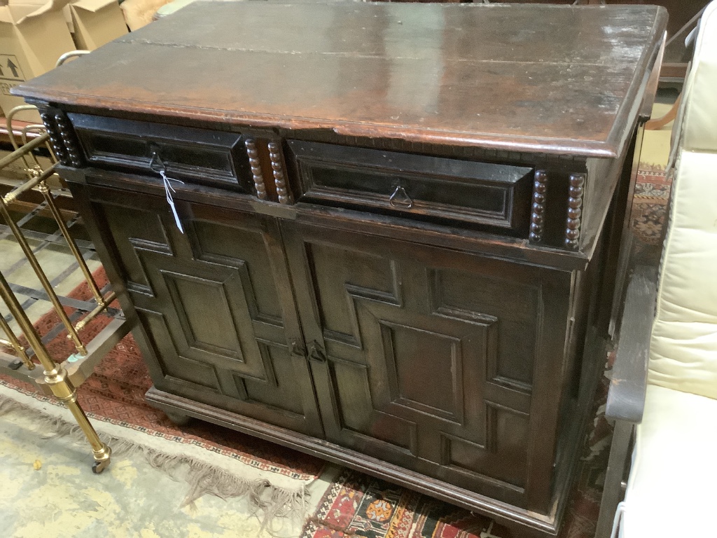 An early 18th century and later oak cupboard, with two frieze drawers, width 115cm